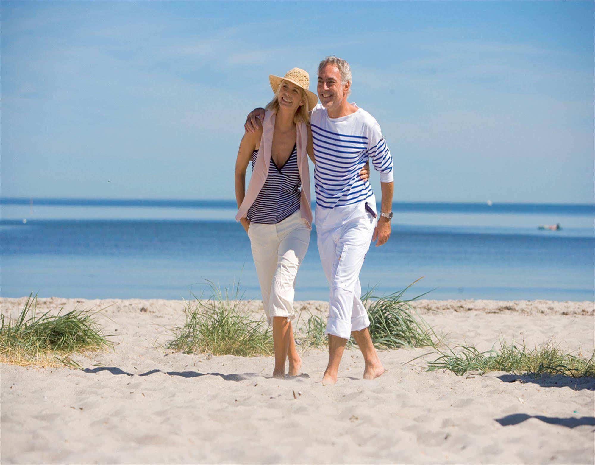 ホテル ヤハトハーフェンレジデンツ ホーへ デューン ロストック エクステリア 写真 A couple walking on the beach